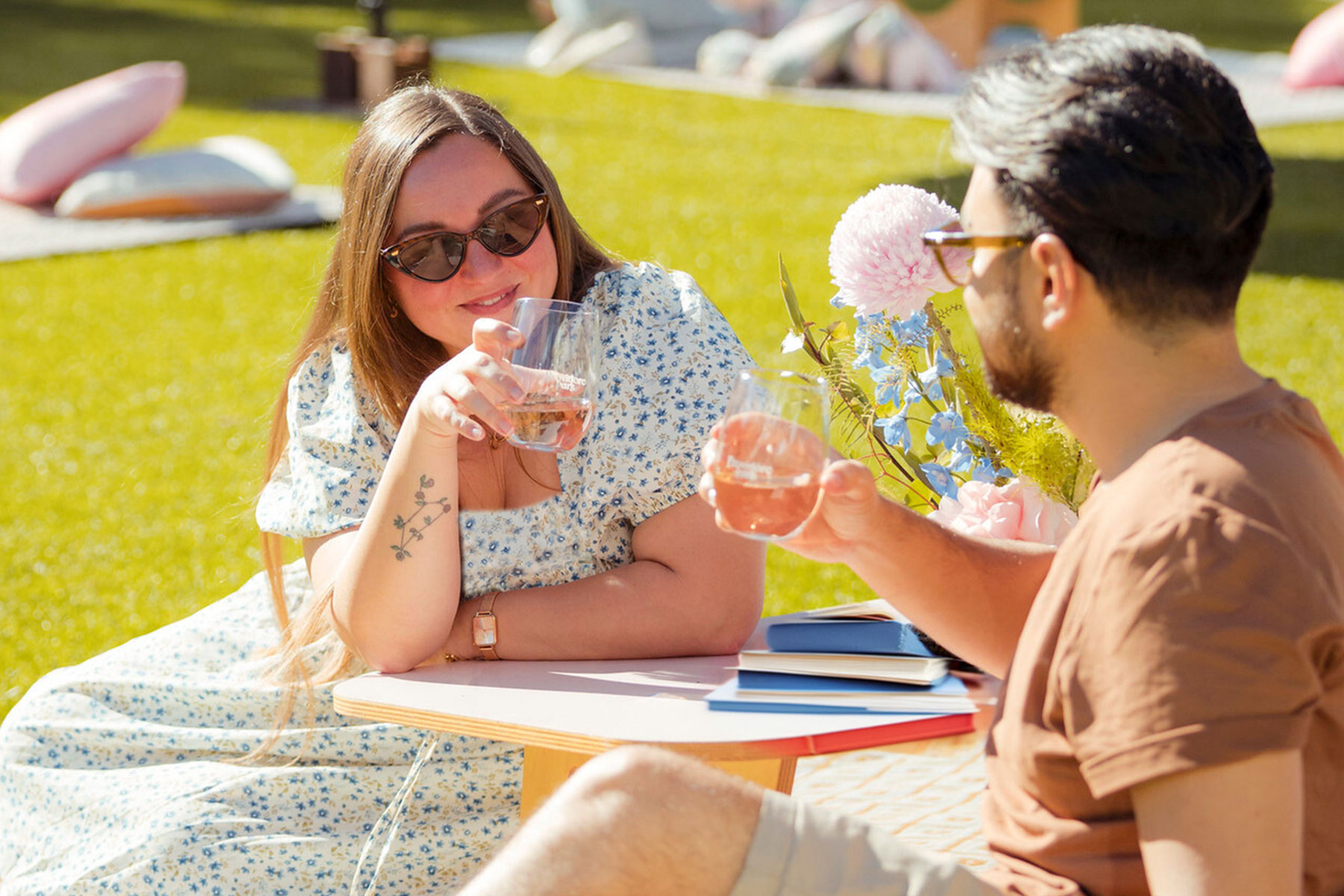 People holding glasses of wine at a table with books on it