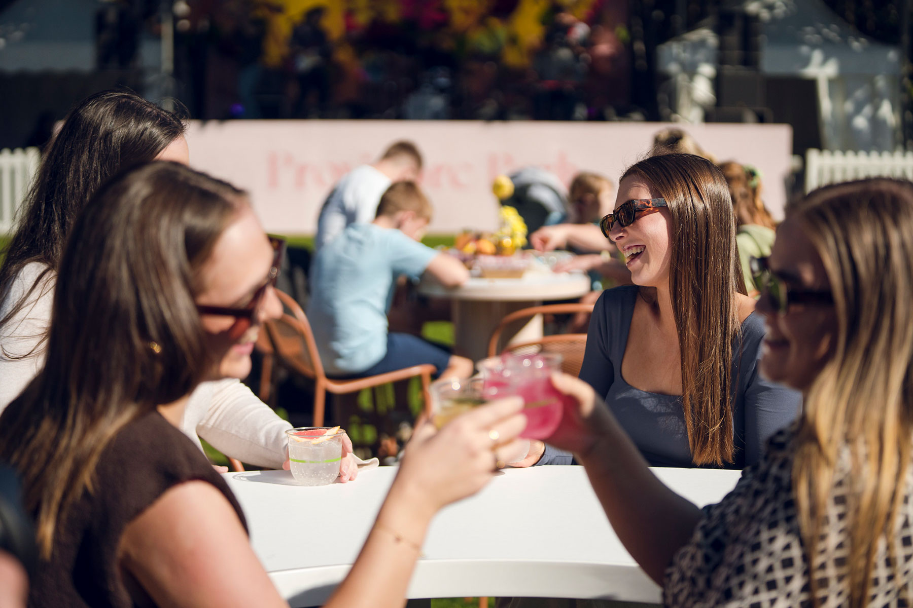 Four people sat at a table cheersing drinks