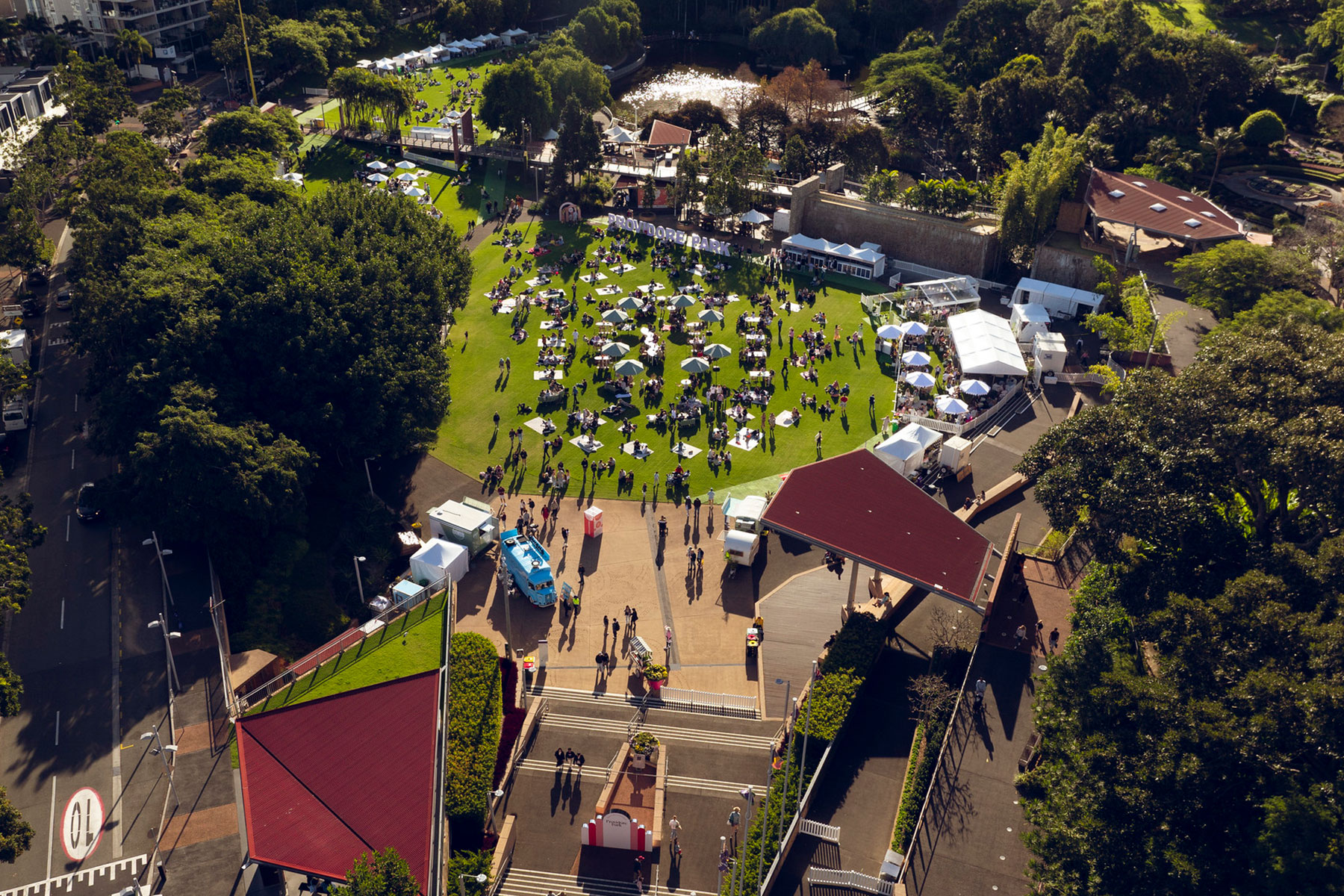 Aerial image of Providore Park event site featuring people white marquees set on green grass on a sunny day
